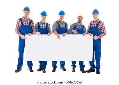 Full length portrait of confident male construction worker holding blank billboard against white background - Powered by Shutterstock