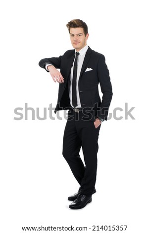 Full length portrait of confident young businessman leaning on invisible wall over white background
