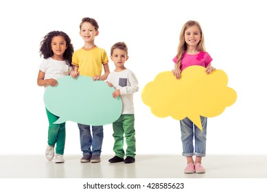 Full Length Portrait Of Cute Little Kids In Casual Clothes Holding Speech Bubbles, Looking At Camera And Smiling, Isolated On A White Background