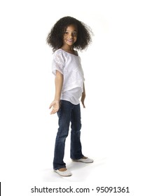 Full length portrait of a cute little African American girl dancing against white background