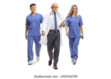 Full Length Portrait Of A Doctor With A Male And Female Nurse Walking Isolated On White Background