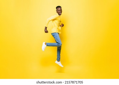 Full Length Portrait Of Ecstatic African Man Jumping In Isolated Yellow Color Studio Background