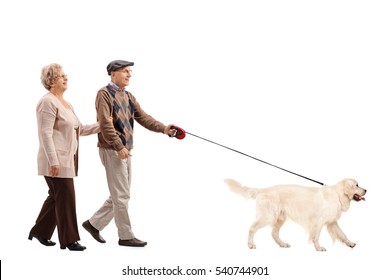 Full Length Portrait Of An Elderly Couple Walking A Dog Isolated On White Background