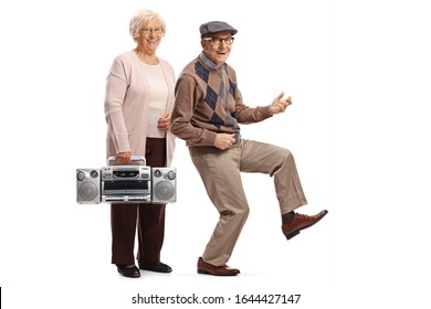 Full length portrait of an elderly woman with a boombox and a senior man dancing and pretending to play a guitar isolated on white background