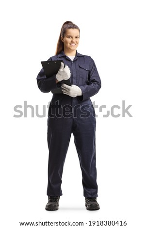 Full length portrait of a female mechanic in a uniform standing and looking at camera isolated on white background