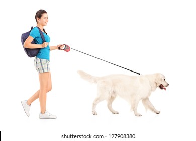 Full Length Portrait Of A Female Student Walking Her Dog Isolated On White Background