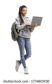 Full length portrait of a female student standing with a laptop computer and looking at the camera isolated on white background