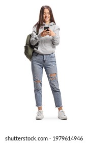 Full length portrait of a female student typing on a mobile phone and smiling isolated on white background