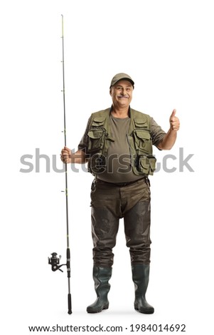 Full length portrait of a fisherman in a uniform standing with a fishing rod and showing thumbs up isolated on white background