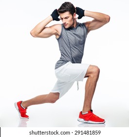 Full length portrait of a fitness man stretching isolated on a white background