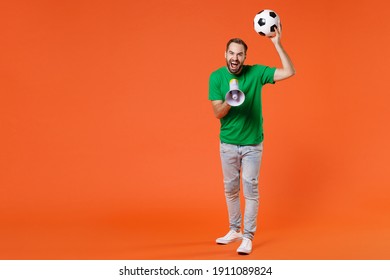 Full Length Portrait Funny Man Football Fan In Basic Green T-shirt Cheer Up Support Favorite Team With Soccer Ball Screaming In Megaphone Isolated On Orange Background. People Sport Leisure Concept