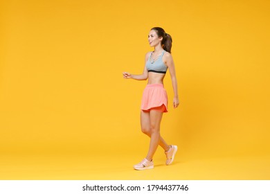 Full Length Portrait Funny Young Fitness Woman In Sportswear Working Out Isolated On Yellow Background Studio Portrait. Workout Sport Motivation Lifestyle Concept. Mock Up Copy Space. Walking, Going