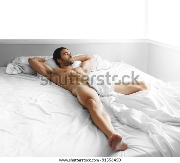 全长肖像的一个华丽性感的裸体男性模型铺设在床库存照片 立即编辑
