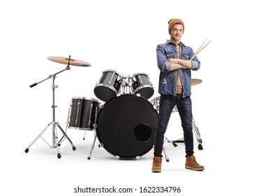 Full length portrait of a guy in casual clothes holding drumsticks and posing with a drum set isolated on white background