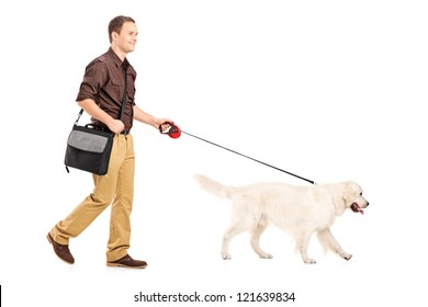 Full Length Portrait Of A Guy With Shoulder Bag Walking A Dog Isolated On White Background