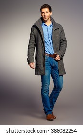 Full Length Portrait Of A Handsome Man Wearing Jeans Clothes And A Coat. Men's Beauty, Seasonal Fashion. Studio Shot.