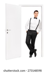 Full length portrait of a handsome young man in elegant clothes posing by an opened door isolated on white background - Shutterstock ID 273148598