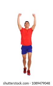 Full length portrait of happy asian man running with arms raised and clenched fist on white background