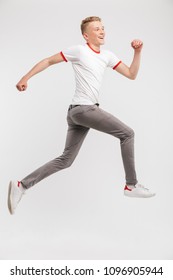 Full Length Portrait Of Happy Caucasian Teenage Boy 16-18 Years Old In Streetwear Smiling While Running Isolated Over White Background