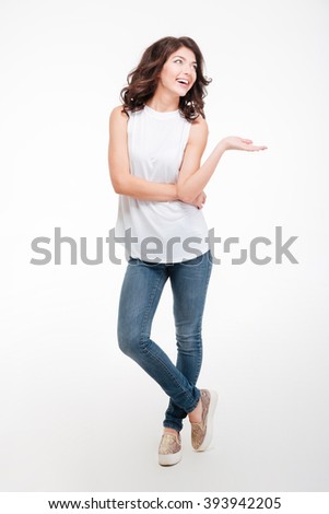 Full length portrait of a happy thoughtful woman holding copyspace on the palm isolated on a white background