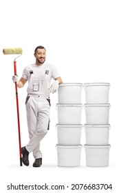 Full Length Portrait Of A House Painter Leaning On Buckets With Paint Isolated On White Background