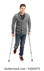 Full Length Portrait Of An Injured Young Man On Crutches Isolated On White Background