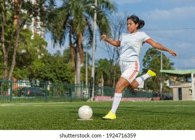 Full length portrait of a latin female soccer player about to kick the ball. Female football player concept - Powered by Shutterstock