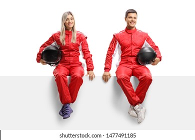 Full Length Portrait Of A Male And Female Car Racers Sitting On Panel In Red Uniforms Isolated On White Background