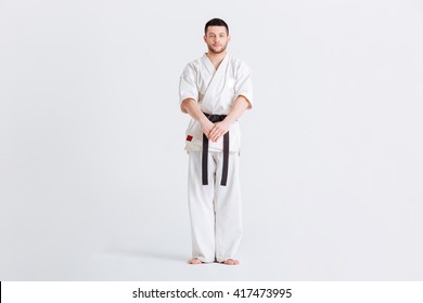 Full Length Portrait Of A Male Fighter In Kimono Standing Isolated On A White Background