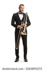 Full length portrait of a male musician holding a trombone and looking down isolated on white background