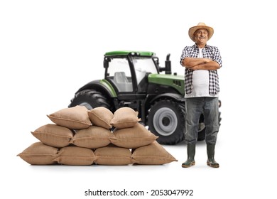 Full Length Portrait Of A Mature Farmer Posing Next To A Green Tractor Isolated On White Background