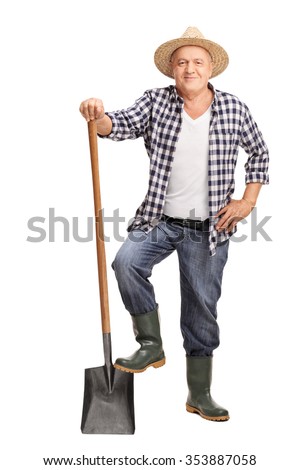 Full length portrait of a mature farmer posing with a shovel isolated on white background