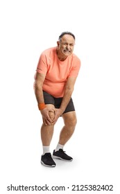 Full length portrait of a mature man in sportswear holding his painful knee isolated on white background