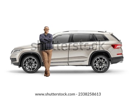 Full length portrait of a mature man leaning on a new SUV isolated on white background