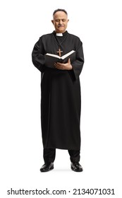 Full length portrait of a mature priest standing and reading the bible isolated on white background