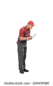 Full Length Portrait Of A Mechanic In A Gray Jumpsuit Writing Down Notes On A Clipboard Isolated On White Background