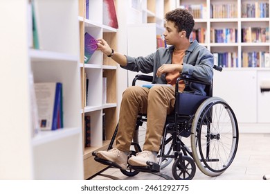 Full length portrait of Middle Eastern teenage boy using wheelchair in school library and choosing books on shelf copy space - Powered by Shutterstock