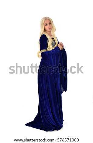 Full length portrait on a beautiful young woman with long blonde hair, wearing a blue velvet medieval gown. standing pose, isolated on white background.