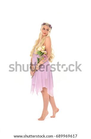 Full length portrait of a pretty blonde girl  wearing a purple fairy dress. standing pose, isolated against white background.