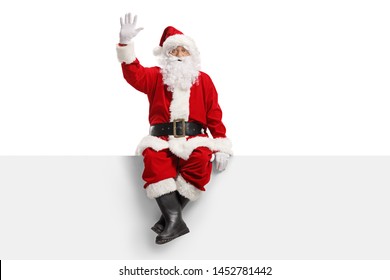 Full length portrait of santa claus sitting on a panel and waving isolated on white background - Powered by Shutterstock