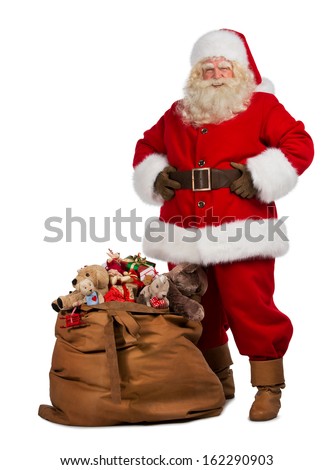 Full length portrait of a Santa Claus posing near a bag full of gifts isolated on white background