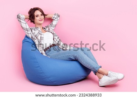 Full length portrait of satisfied glad person sit comfy bag hands behind head isolated on pink color background