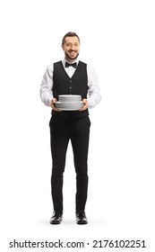 Full length portrait of a server holding a pile of plates and smiling isolated on white background