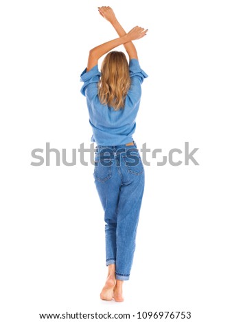Full length portrait of a smiling cute young woman in blue jeans standing isolated on a white background