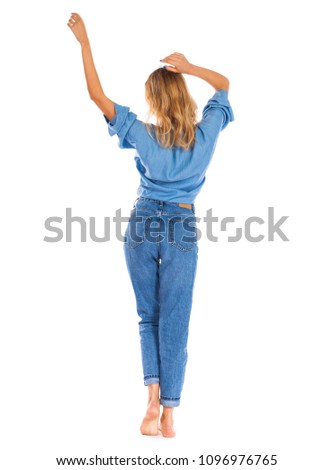 Full length portrait of a smiling cute young woman in blue jeans standing isolated on a white background