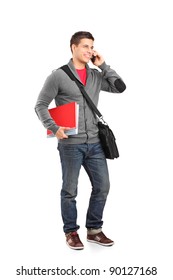 Full Length Portrait Of A Smiling School Boy Holding Books And Talking On A Phone Isolated On White Background