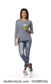 Full Length Portrait Of Smiling Young Woman Holding Laptop And Cup Of Coffee. Looking At Camera. Isolated On A White Background