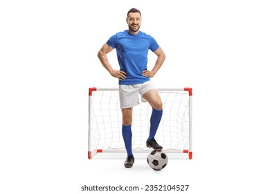 Full length portrait of a soccer player posing with a ball in front of a mini goal isolated on white background - Powered by Shutterstock