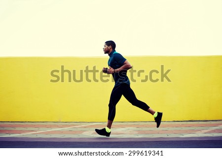 Full length portrait of strong male jogger with muscular body running fast against bright copy space background for your text message or content, pumped man working out while jogging outdoors in city