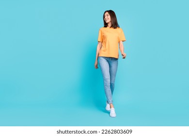 Full length portrait of stunning positive lady walking look empty space isolated on blue color background